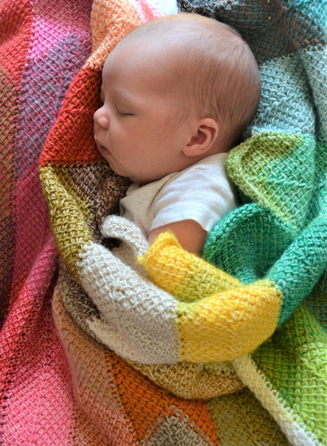tunisian crochet chevron style blanket created by using mini skeins and crochet panels, joined together as you go