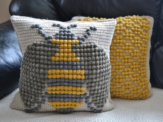 crochet pillow cover featuring crochet bobble stitches to create a bumble bee motif