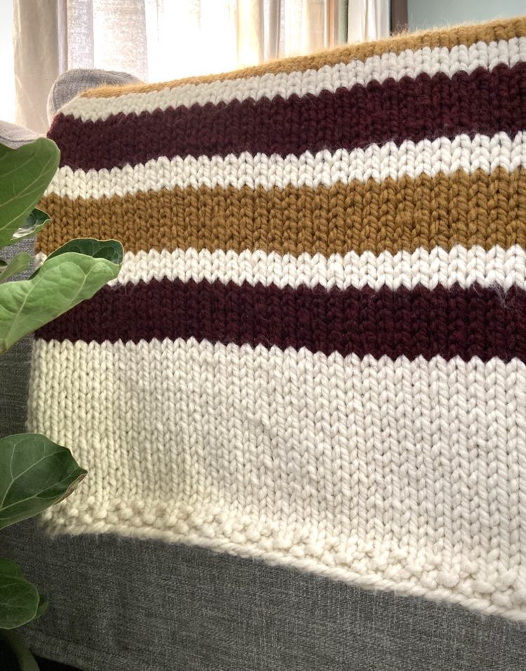 super bulky knit blanket with alternating stripes of color