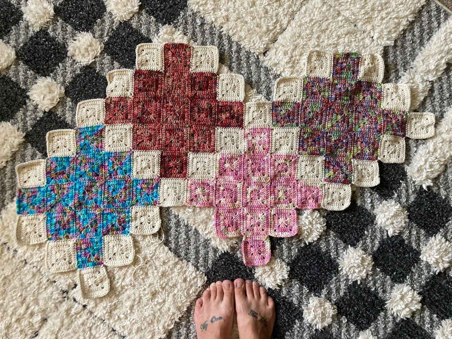 crochet quilt style blanket uses solid granny squares to create cross patterns across the blanket
