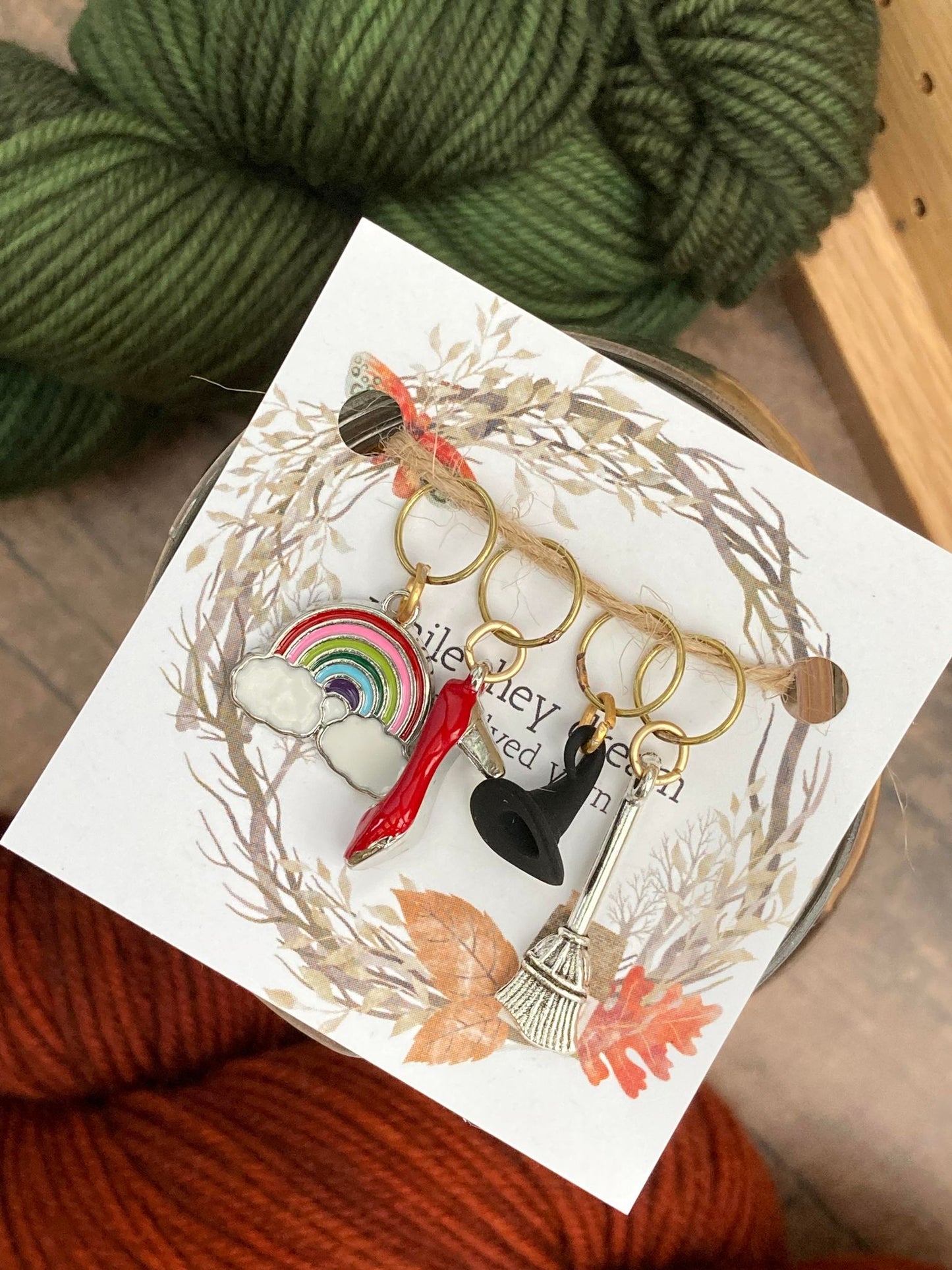 rainbow stitch marker, ruby slipper stitch marker, witch hat stitch marker, and silver broom stitch marker