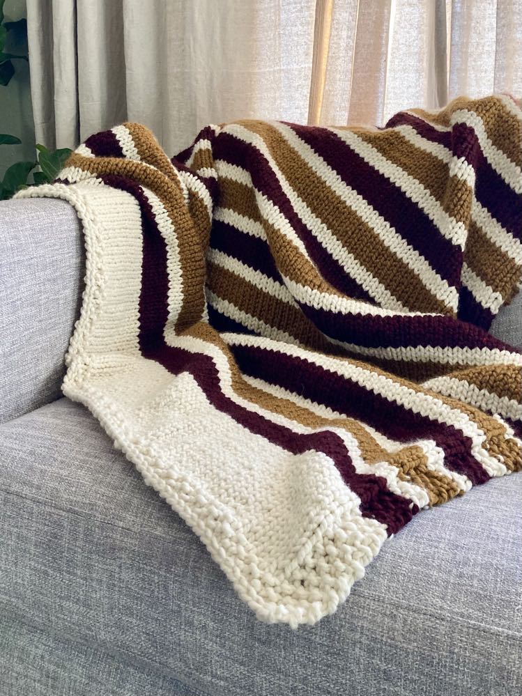 super bulky knit blanket with alternating stripes of color