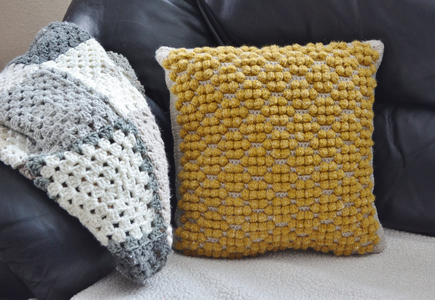 crochet pillow cover with crochet bobble stitches that look like honeycomb