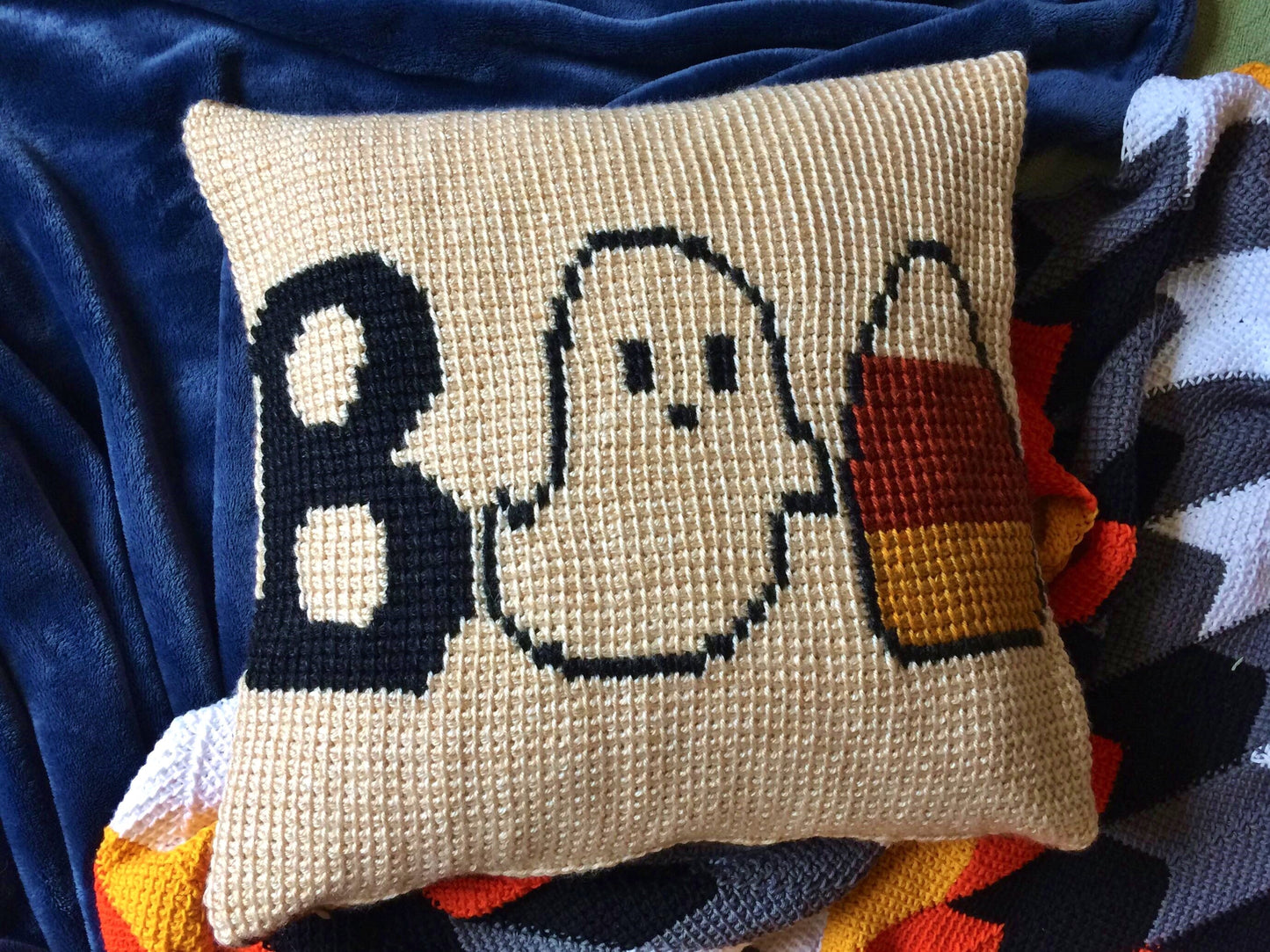 tunisian crochet halloween pillow featuring a capital B, a Ghost, and a Candy Corn to represent BOO