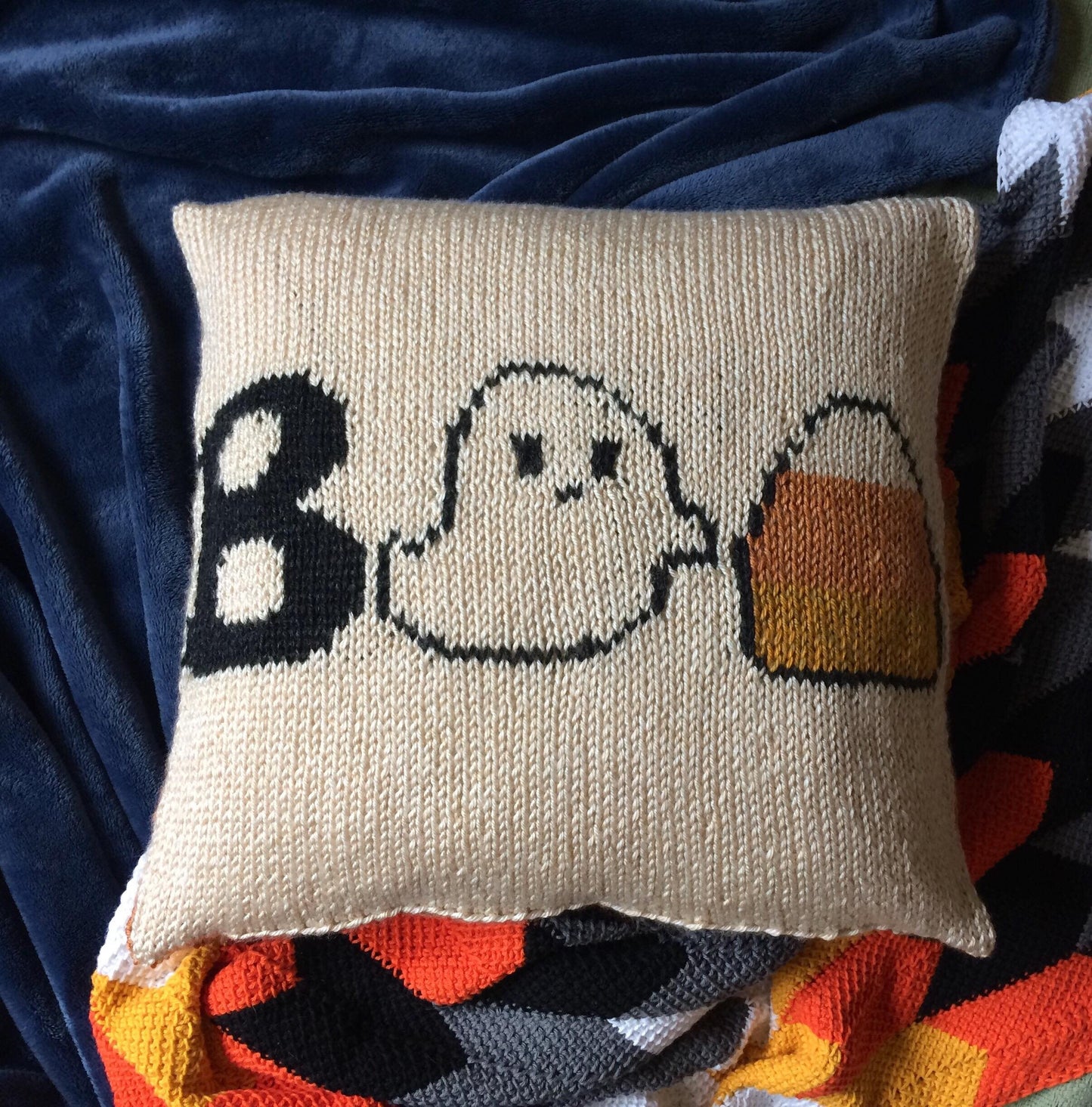 knit halloween pillow featuring a capital B, a Ghost, and a Candy Corn to represent BOO