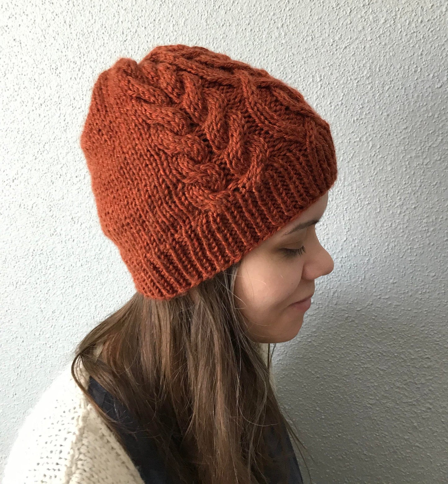 cable knit hat featuring a celtic braid up the middle with braids to each side with a stockinette backside