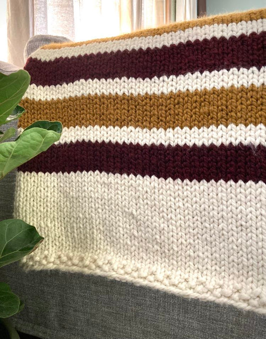super bulky knit blanket with alternating stripes of color