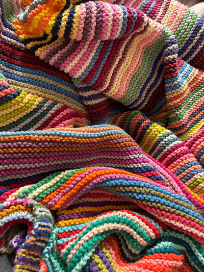 Knit garter stitch blanket using a rainbow of colors in Scheepjes Cahlista yarn