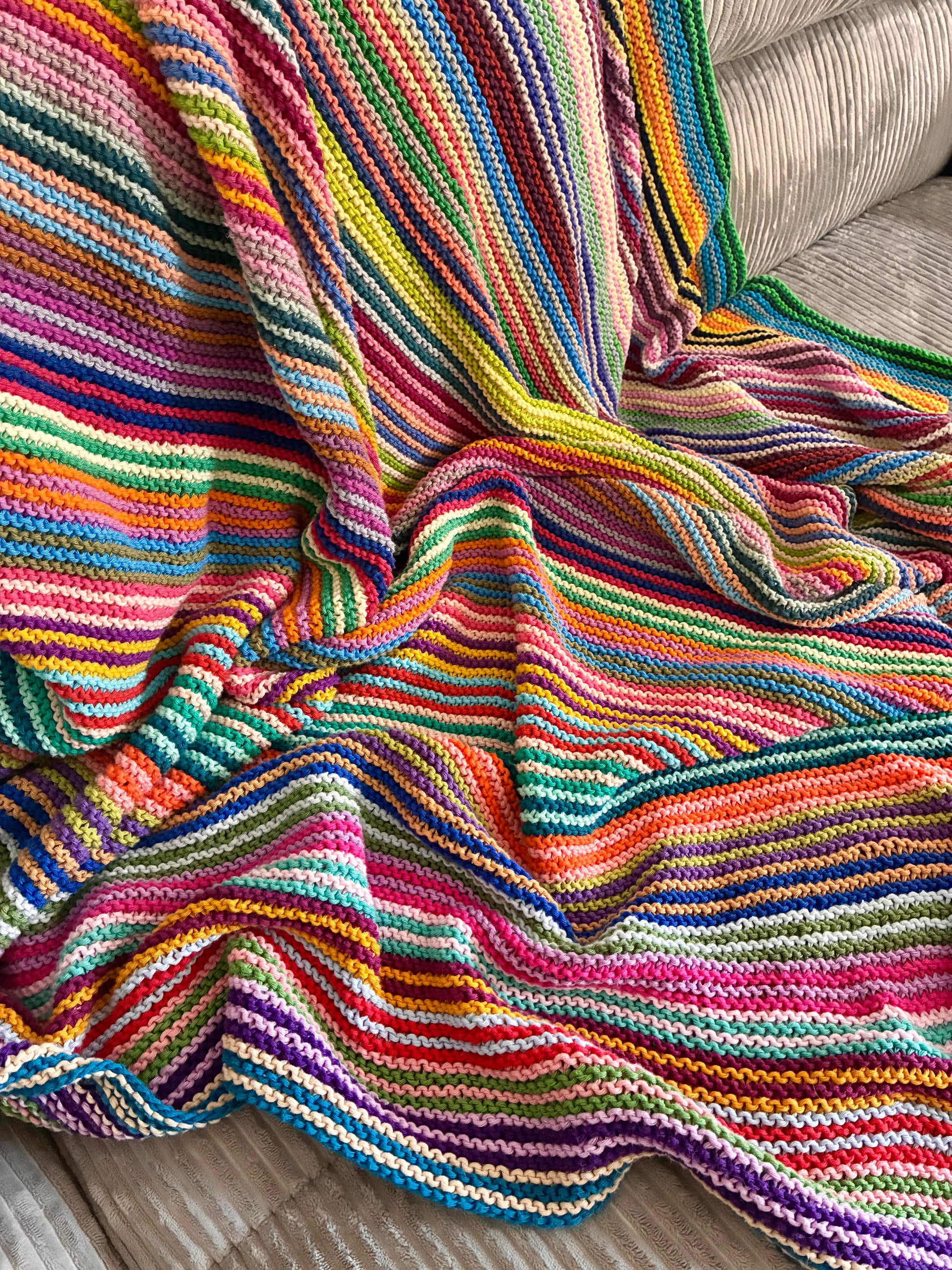 Knit garter stitch blanket using a rainbow of colors in Scheepjes Cahlista yarn